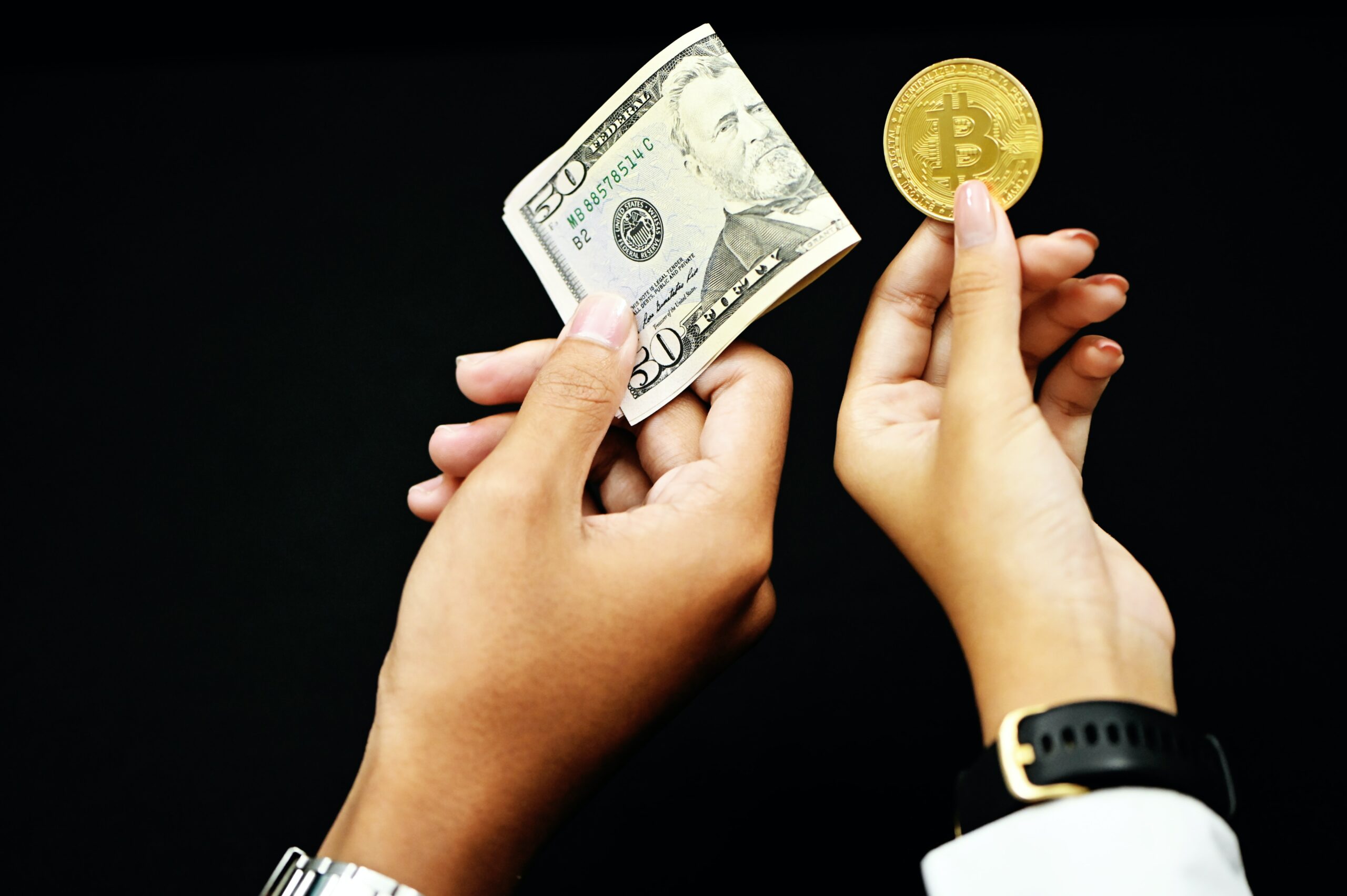 one holding a 50 dollar bill and a bitcoin for another