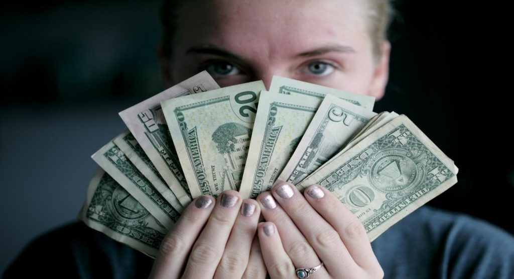 girl holding 20 dollar bill